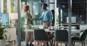 Business woman, man and shaking hands in office for b2b collaboration, deal or welcome with hello a