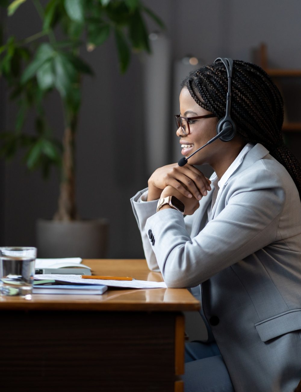 Friendly afro woman remote callcenter worker in headset with microphone communicating with customers