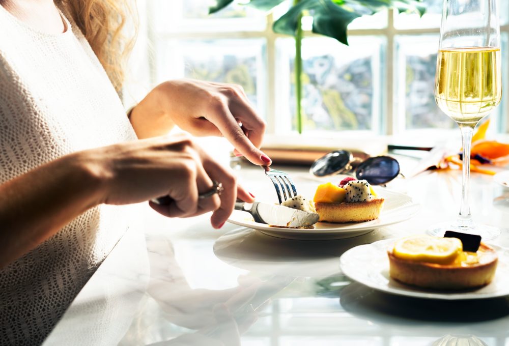 Woman is eating pastry at the restaurant
