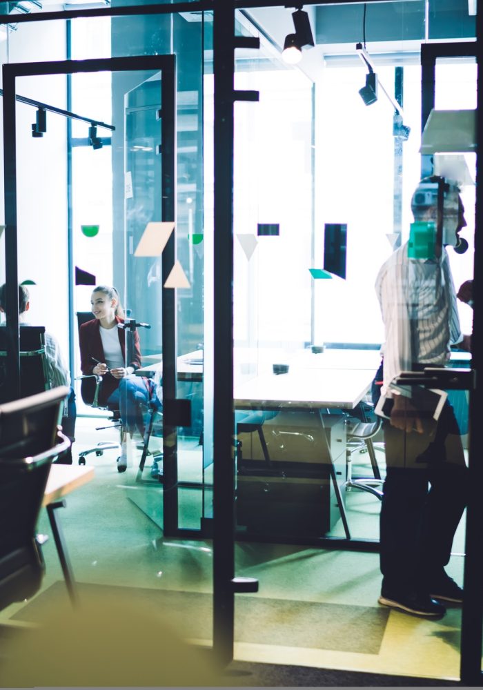 Work partners standing in meeting room of corporation